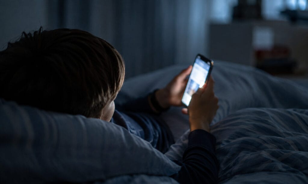criança usando rede social no celular